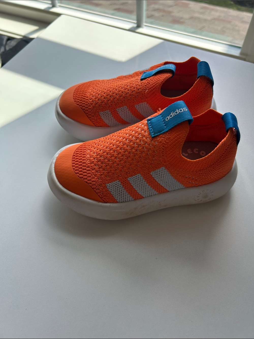 adidas Kids Bright Orange Slip-On Sneakers with Blue Tabs and White Stripes